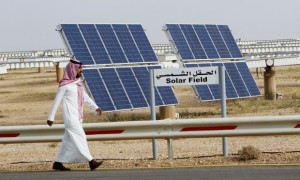 File photo of a Saudi man walking on a street past a field of solar panels at the King Abdulaziz city of Sciences and Technology, Al-Oyeynah Research Station